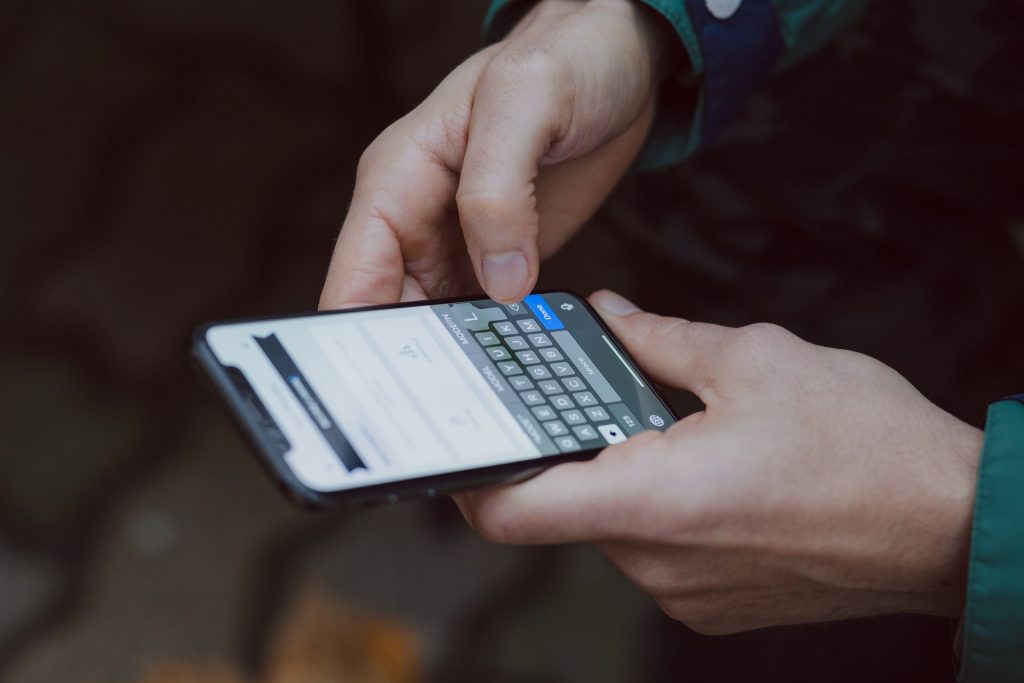 Person typing on an iPhone keyboard.